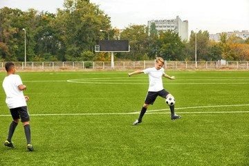 Boys playing football at stadium