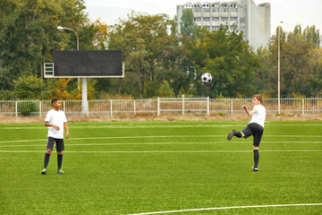 Boys playing football at stadium