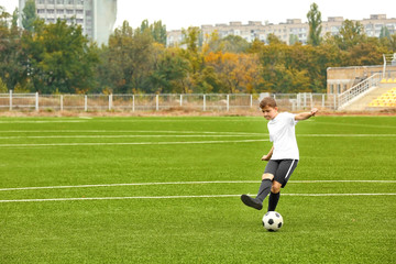 Boy playing football at stadium