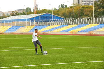 Boy playing football at stadium