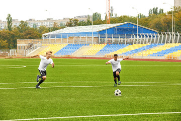 Boys playing football at stadium