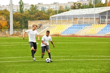Fototapeten Boys playing football at stadium © Africa Studio