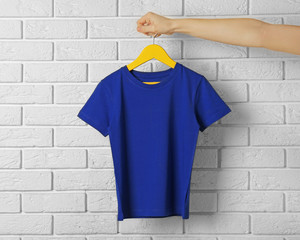 Blank blue t-shirt against brick wall