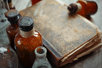 Old book with glass bottles, closeup