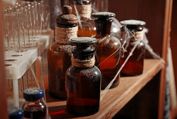 Vintage equipment of chemical laboratory on wooden shelf, closeup