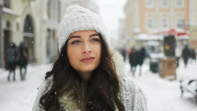 Attractive beautiful lady walking over snowy city background