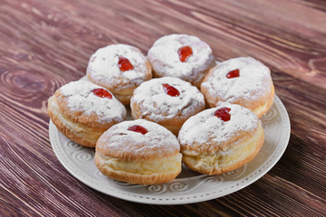 Plate with tasty donuts for Hanukkah on wooden table, closeup