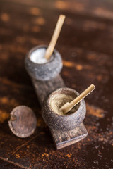 Pepper and salt in traditional balinese wooden dish on old wooden table