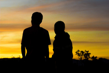 Man and two women stood watching the sunset.