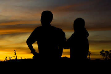 Fototapeta na wymiar Man and two women stood watching the sunset.