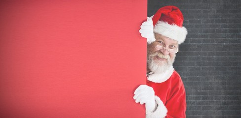 Composite image of santa claus peeking from red board