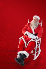 Composite image of santa claus using digital tablet while relaxi