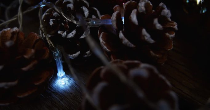 Christmas bauble and pine cone arranged with christmas lights