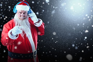Composite image of portrait of santa claus listening to music on