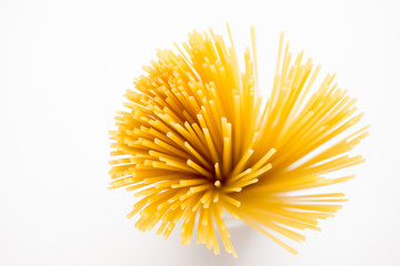 Uncooked pasta spaghetti on white wooden background. Shallow depth of field.