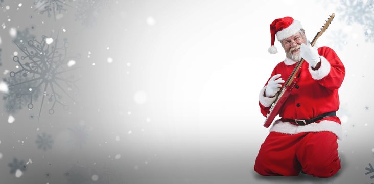 Composite image of cheerful santa claus kneeling and playing gui