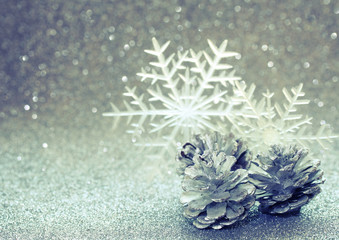 Fototapeta na wymiar Christmas glitter blurred background, three silver pine cone