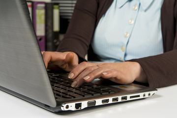 The girl in the office at work at the keyboard.