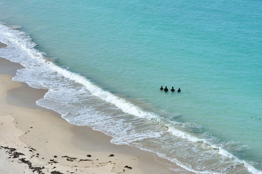 Un groupe de femmes marchent dans l'eau, c'est la pratique du longe côte. Bretagne à Trégastel