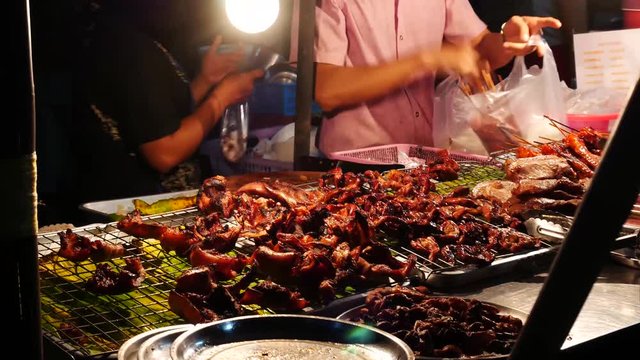 Thai Street Food sellers on night street Grilled Chicken Or BBQ With Charcoal ,Thailand