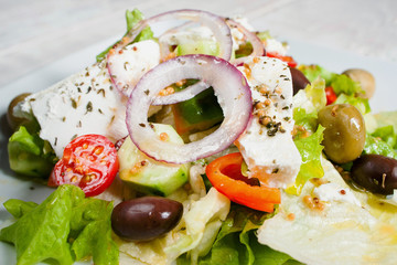 Greek salad with fresh vegetables and feta. Close-up of appetizing side dish with olives and cheese. Mediterranean cuisine, restaurant food, menu concept