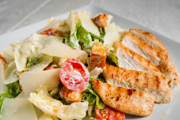 Caesar salad with fried chicken meat, free space. Restaurant serving of side dish with fried poultry and fresh vegetables. Mediterranean cuisine, appetizer, menu concept