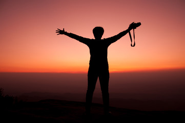 Girl opens arm with sunset sky background, inspiration and freedom concept