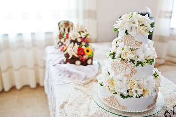 Royal wedding cake with flowers on table.