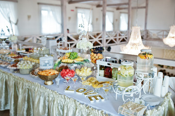 Wedding reception, sweets and fruits. Word love with olives