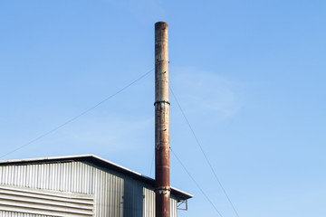 Bio power plant with storage of wooden fuel against blue sky
