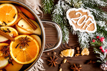 preparation of mulled wine in pot wooden background top view