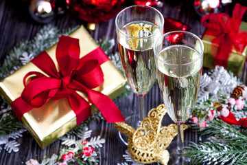 glasses of champagne and Christmas ornaments on dark wooden background