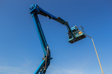 Electric technical repairing street light by boom lift in industrial 
