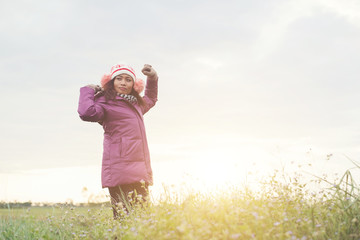 Young girl spreading hands and joy with nature while winter time