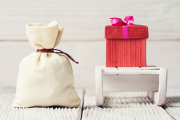 Fototapeta na wymiar Christmas background with gift box, sledge and canvas sack