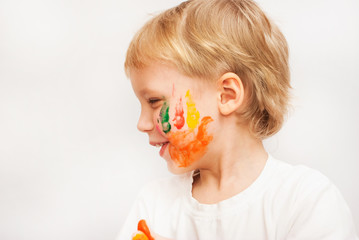  Profile portrait of funny child with colorful hand prints on cheeks.