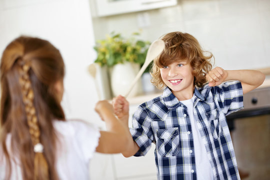 Two Children Fighting In Jest In Kitchen