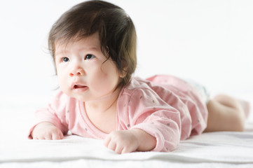 newborn baby girl in pink dress on white background