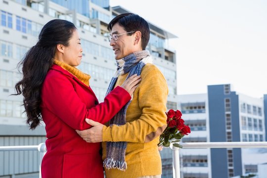 Older Asian Couple On Balcony With Gift