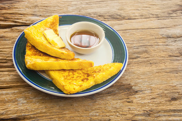 French toast with wild bee honey on wood background. Soft focus effect added to make the feeling of warm morning light.