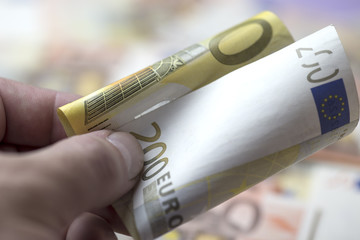 Male arm with 200 euro squeezed banknote