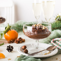 Chocolate pudding mousse with avocado, nuts and christmas decorations. Delicious Christmas themed dinner table.