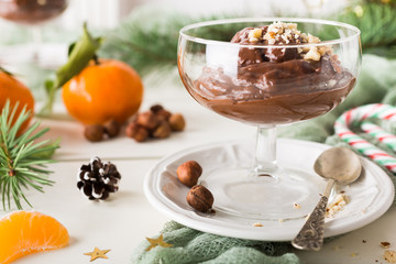 Chocolate pudding mousse with avocado, nuts and christmas decorations. Delicious Christmas themed dinner table.