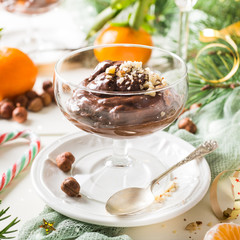 Chocolate pudding mousse with avocado, nuts and christmas decorations. Delicious Christmas themed dinner table.