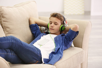 Boy listening music on sofa