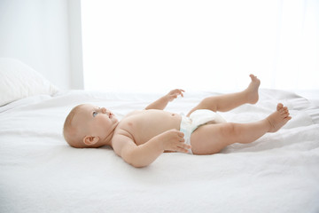 Obraz premium Little baby on white bed in room