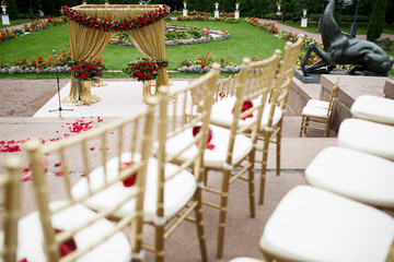 Look over golden chairs at golden wedding altar