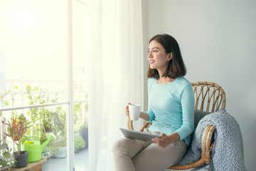 Beautiful asian young woman relaxing and using digital tablet at