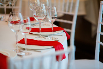 Red serviette lie on white dinner plates