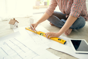 Young handsome male asian architect working at home on the floor